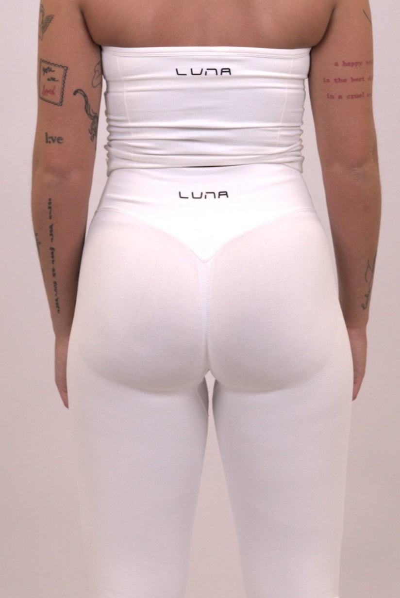 Närbild på scrunch i vita tights – formande seamless passform.